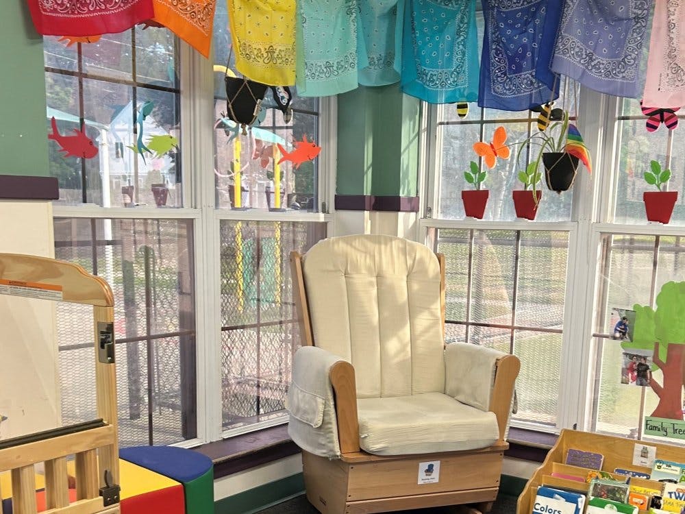 Rocking chair in a brightly decorated classroom by a window