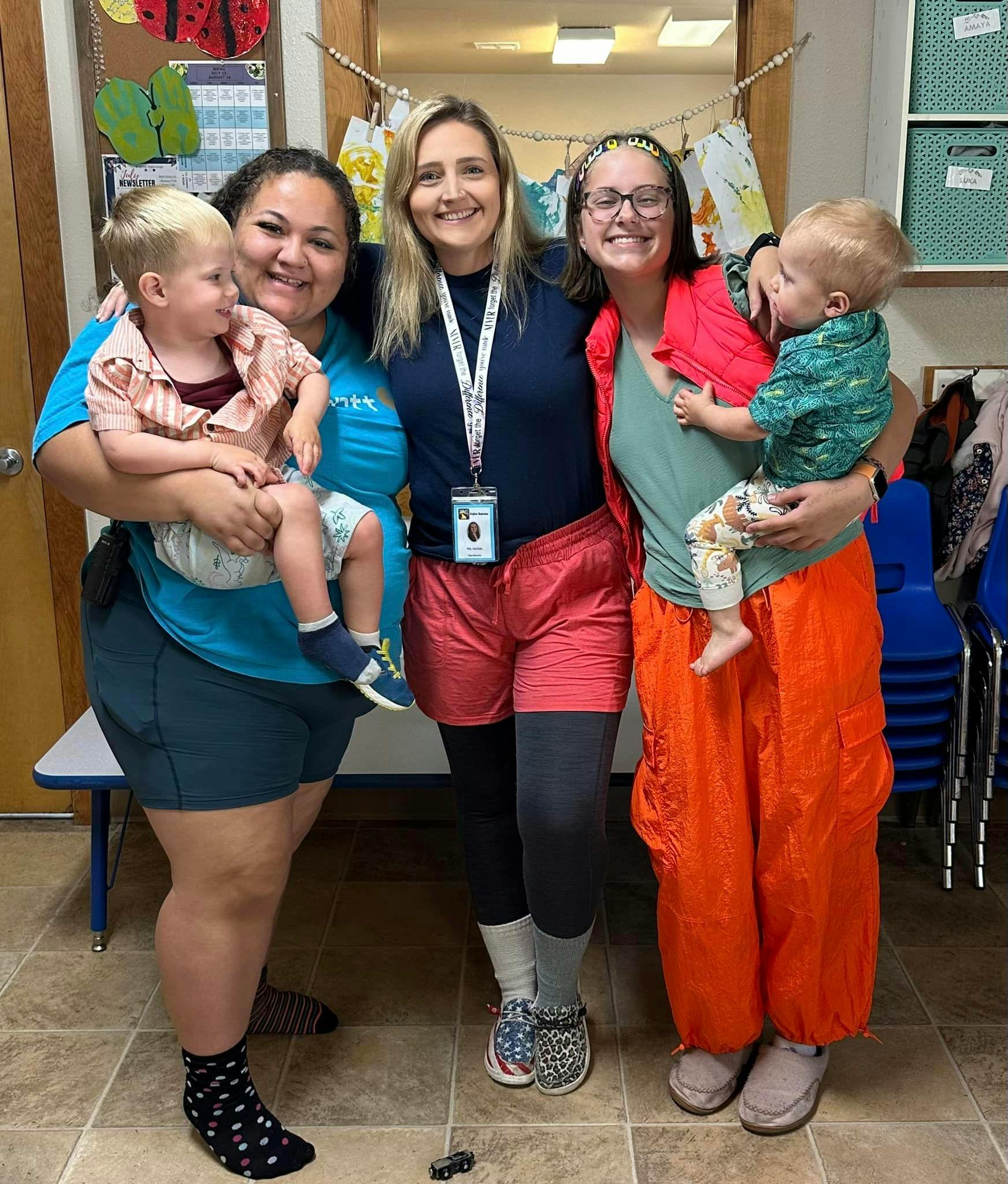Three people holding two children