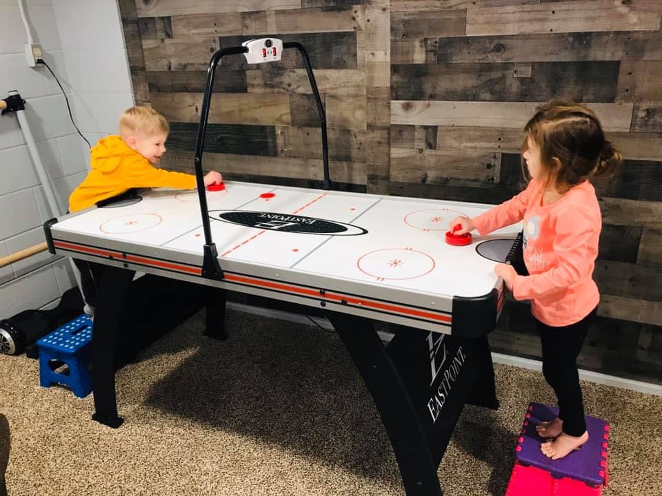 Two children playing air hockey