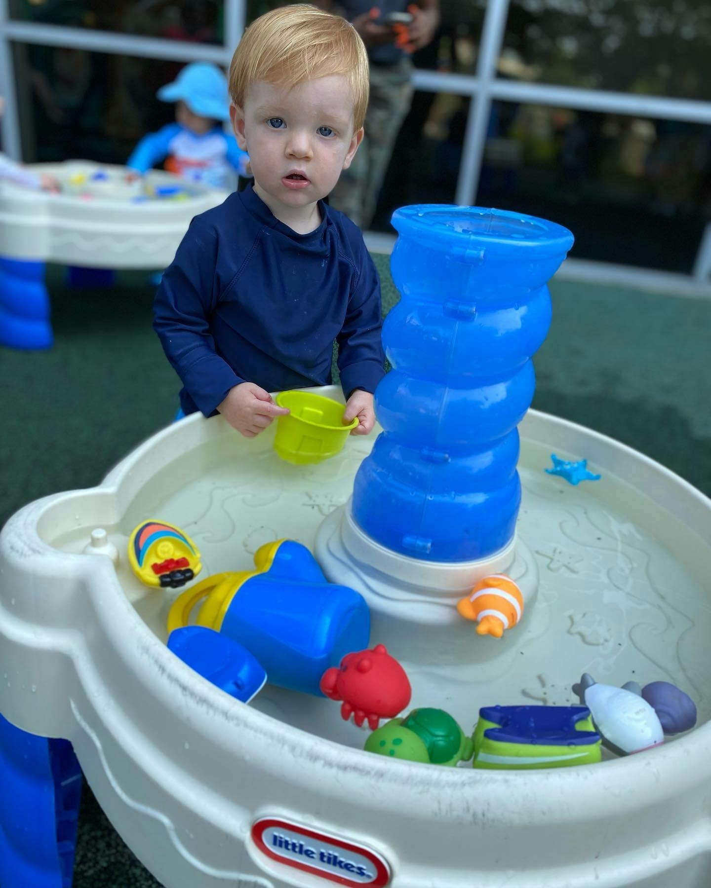 Child playing with a water table and toys