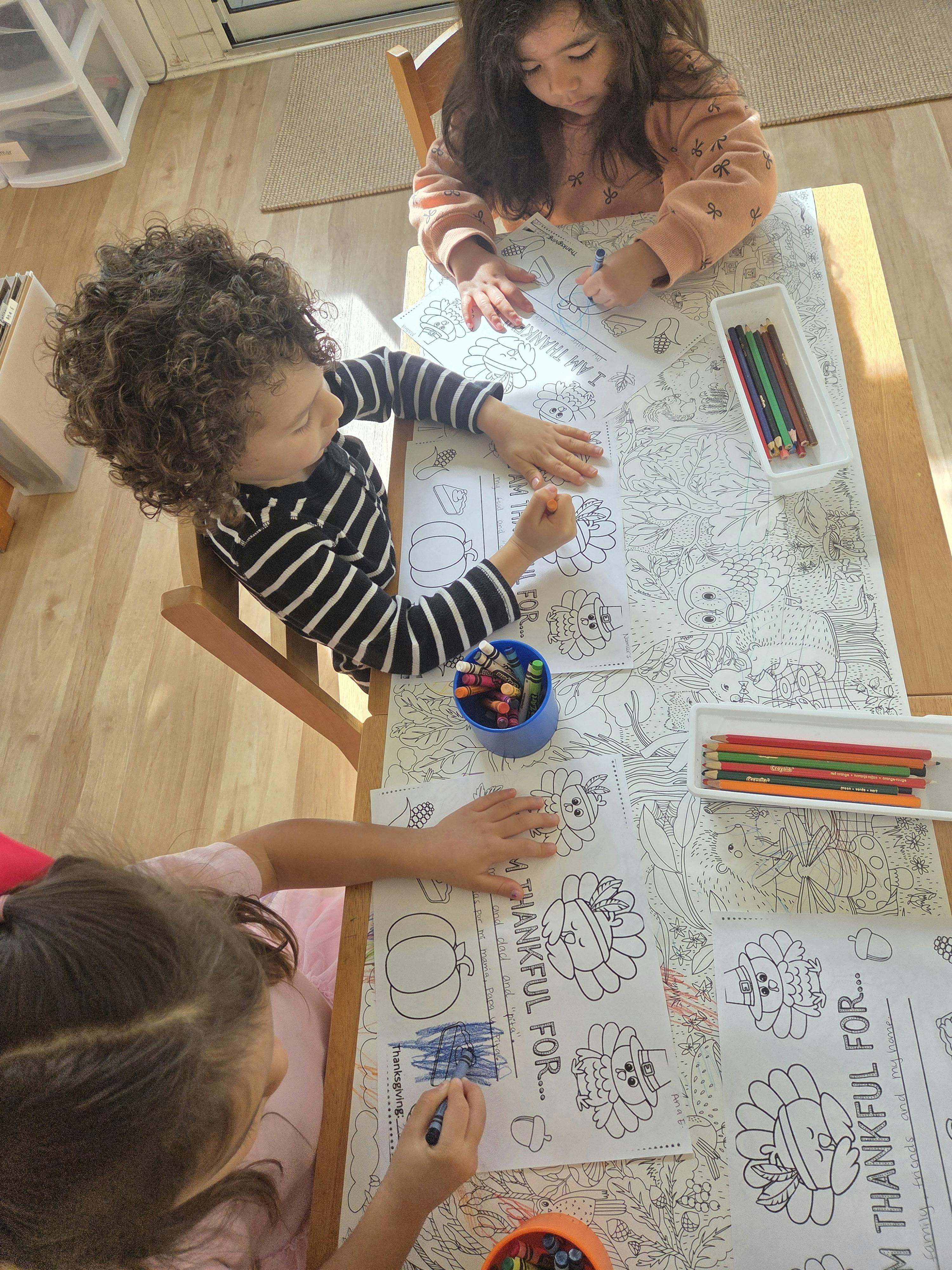 Three children coloring at a table