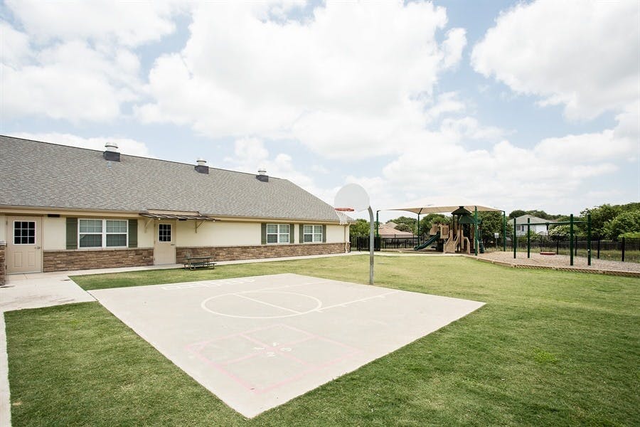 Building exterior with basketball court and playground