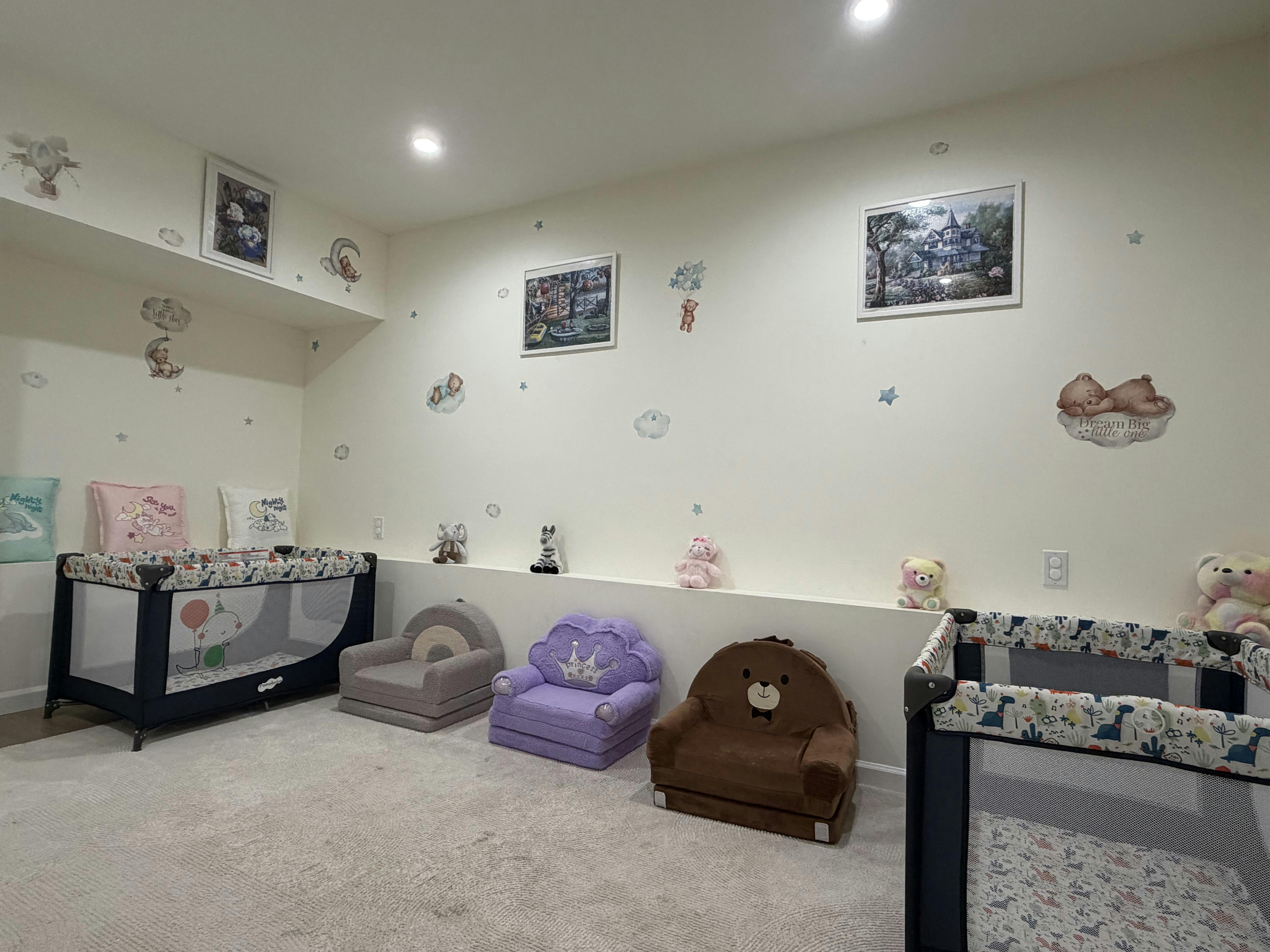 Child bedroom with two playpens and small plush chairs