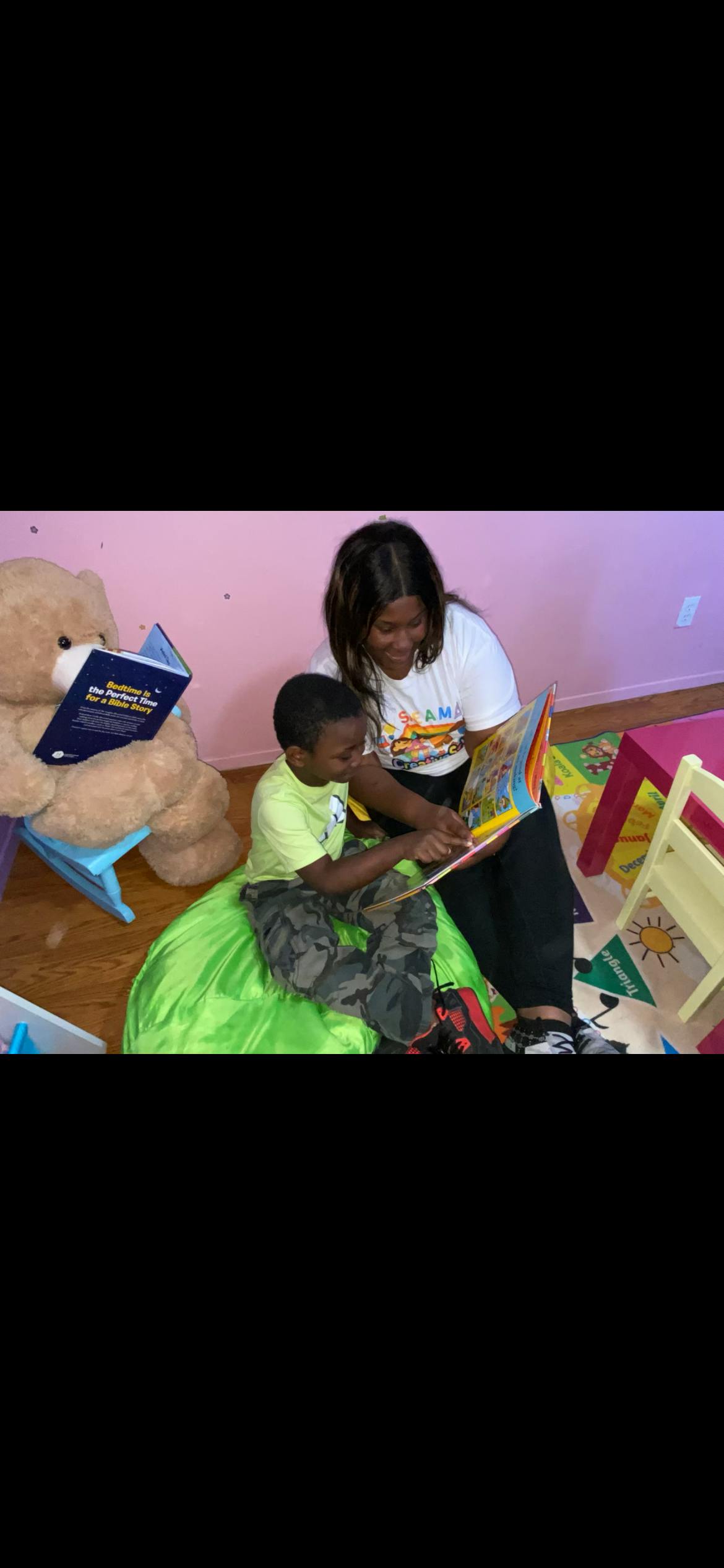 adult and child sitting and reading a book together
