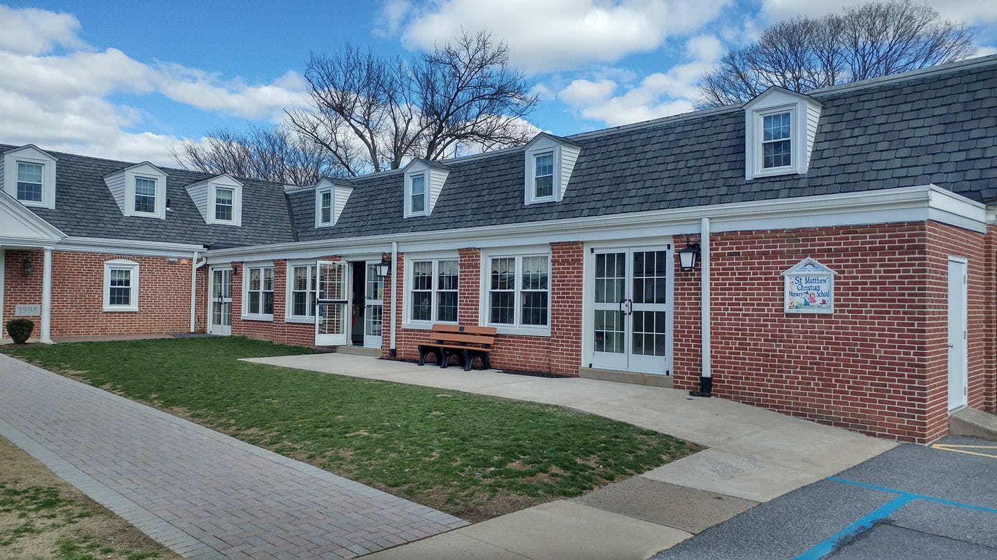 Brick building with a dark roof and white dormer windows