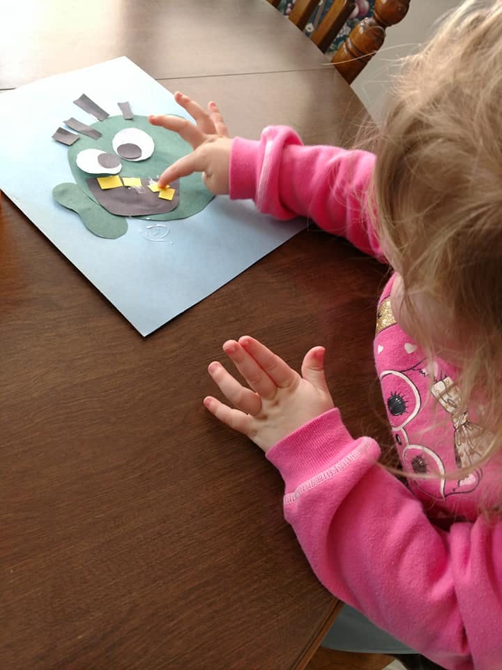 Child making a paper craft monster