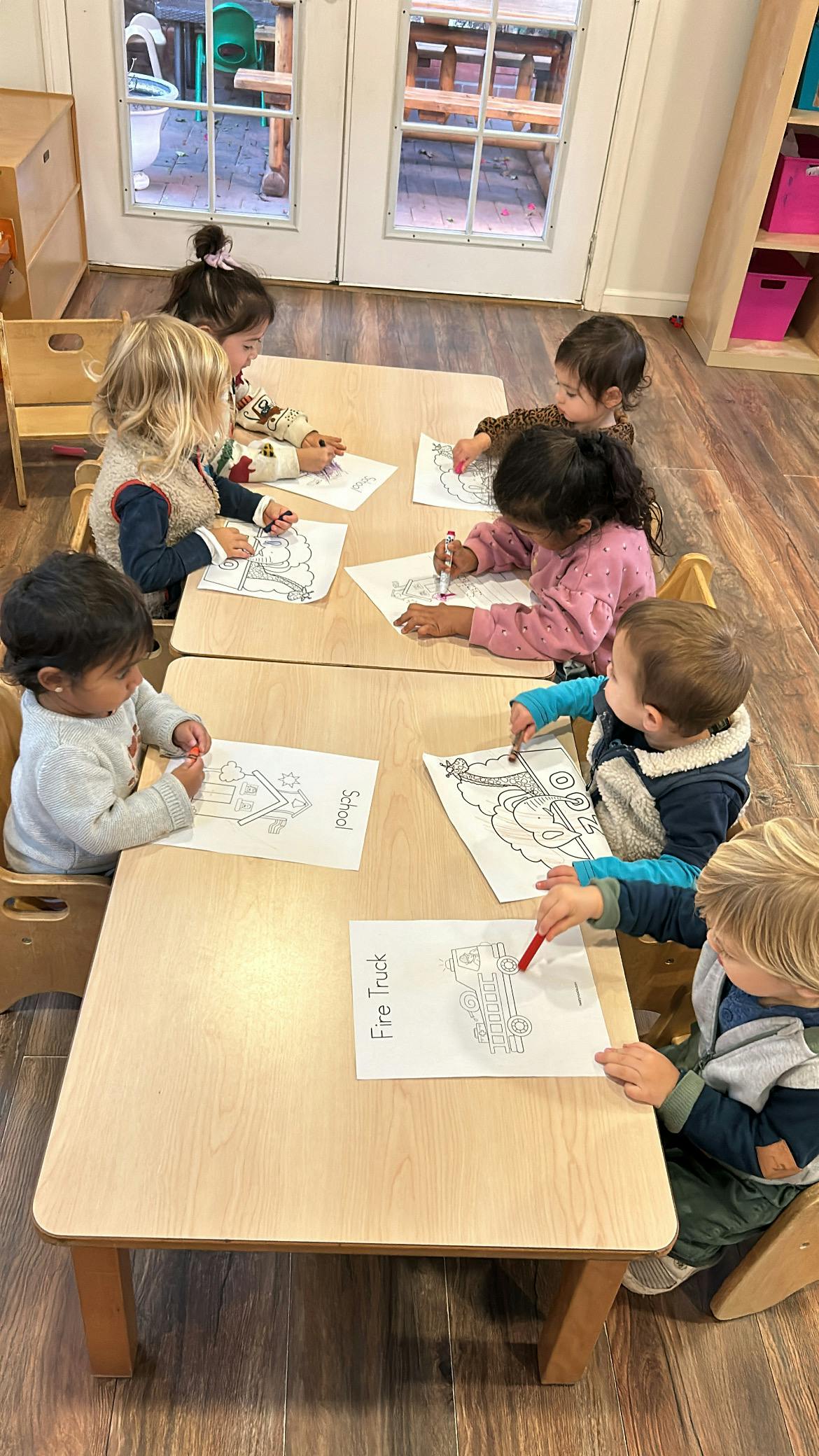 Children coloring at tables in a classroom