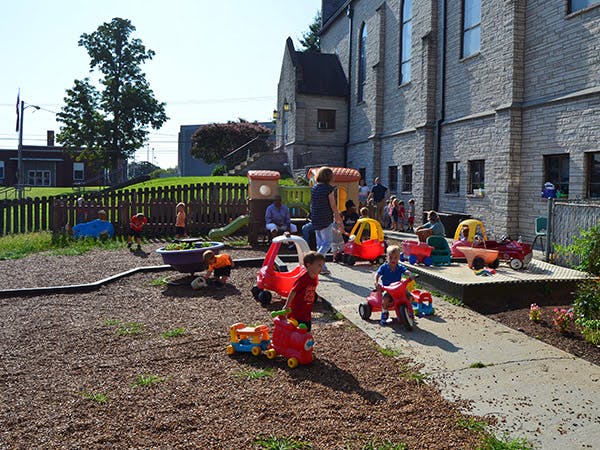 Children playing with ride-on toys on a playground