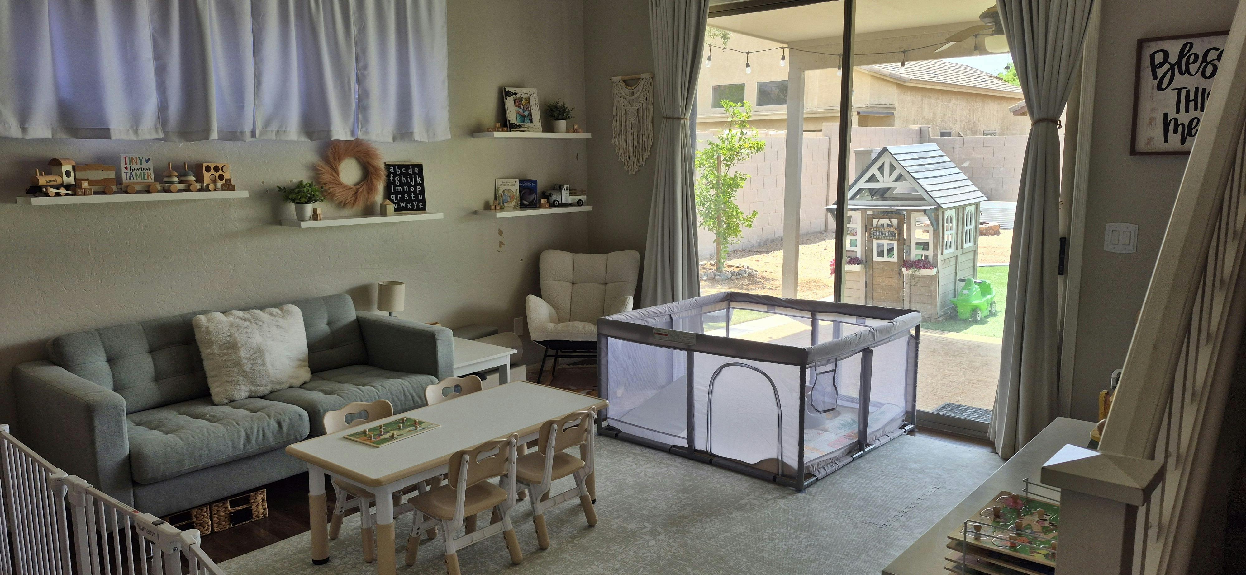 Playroom with a small table, chairs, playpen, and toys