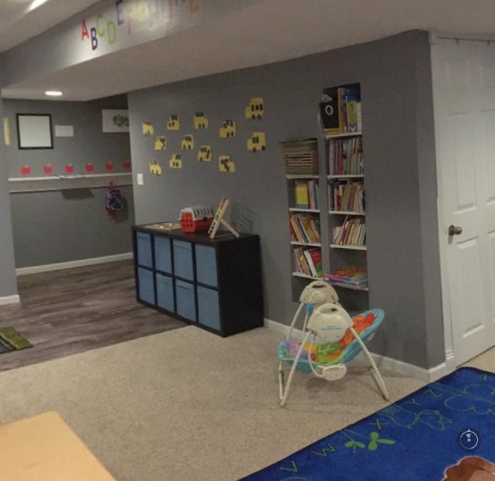 Playroom with storage, bookshelves, and baby swing