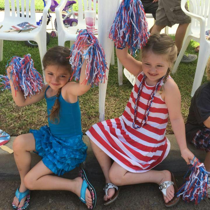 Two children holding red, white, and blue pom-poms