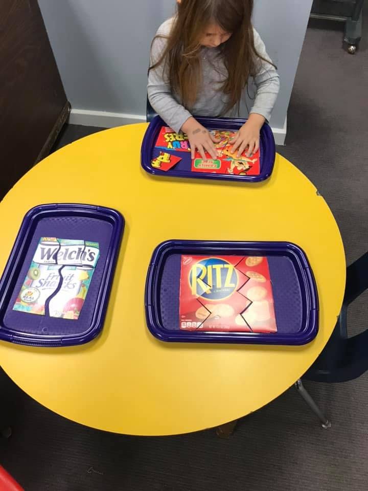 Child playing with puzzles on a yellow table