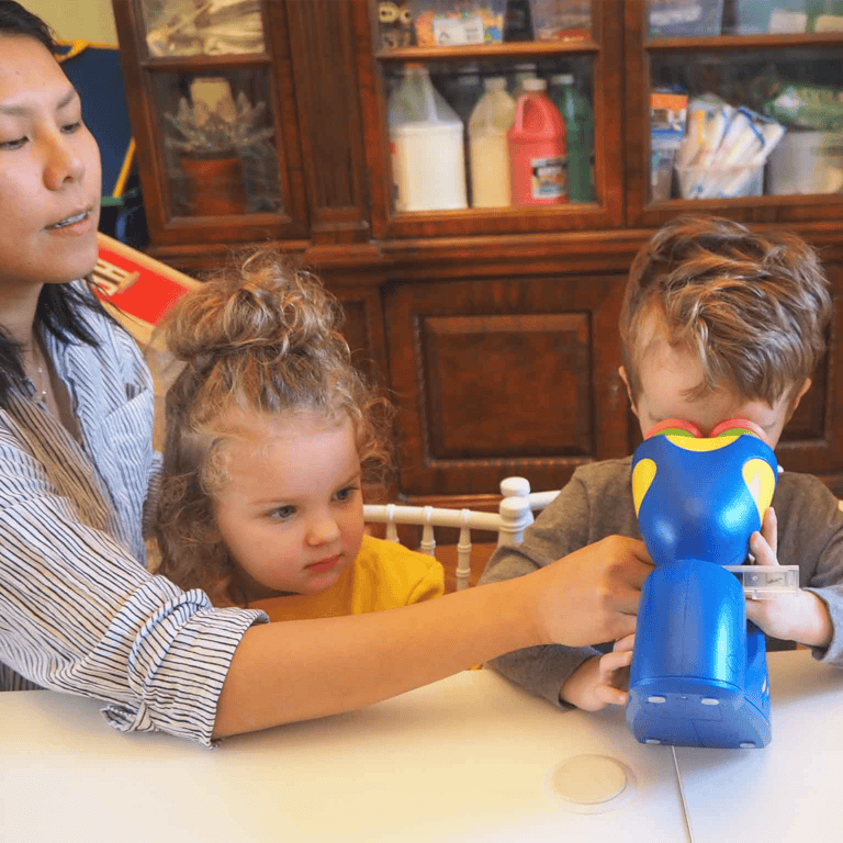 Person and two children playing with a blue toy