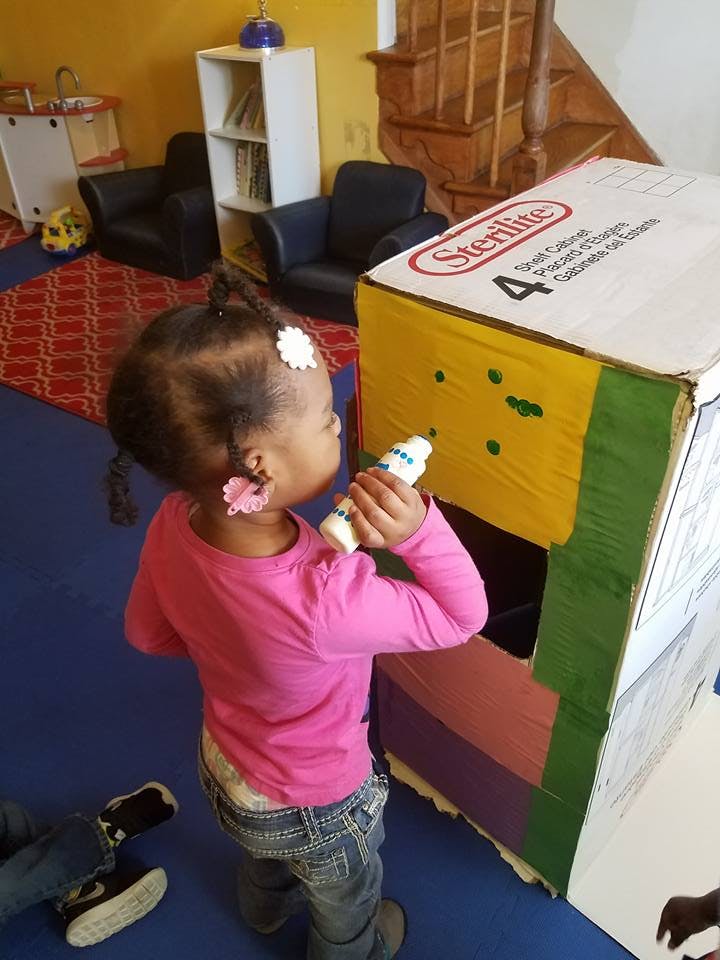 Child playing with a cardboard box structure