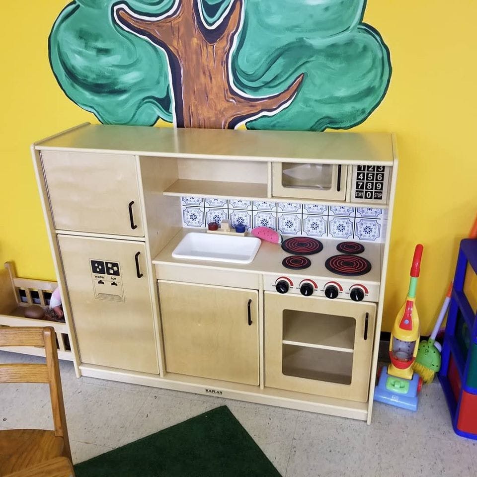 Wooden play kitchen with sink, stove, oven, and microwave