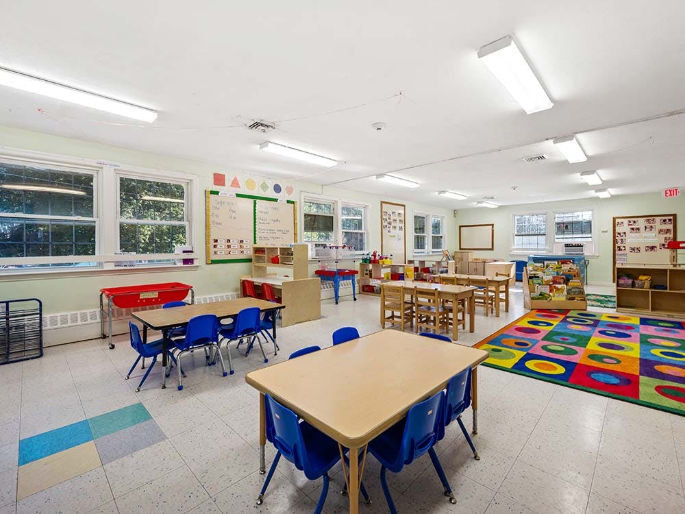 Empty colorful children's classroom with small tables and chairs