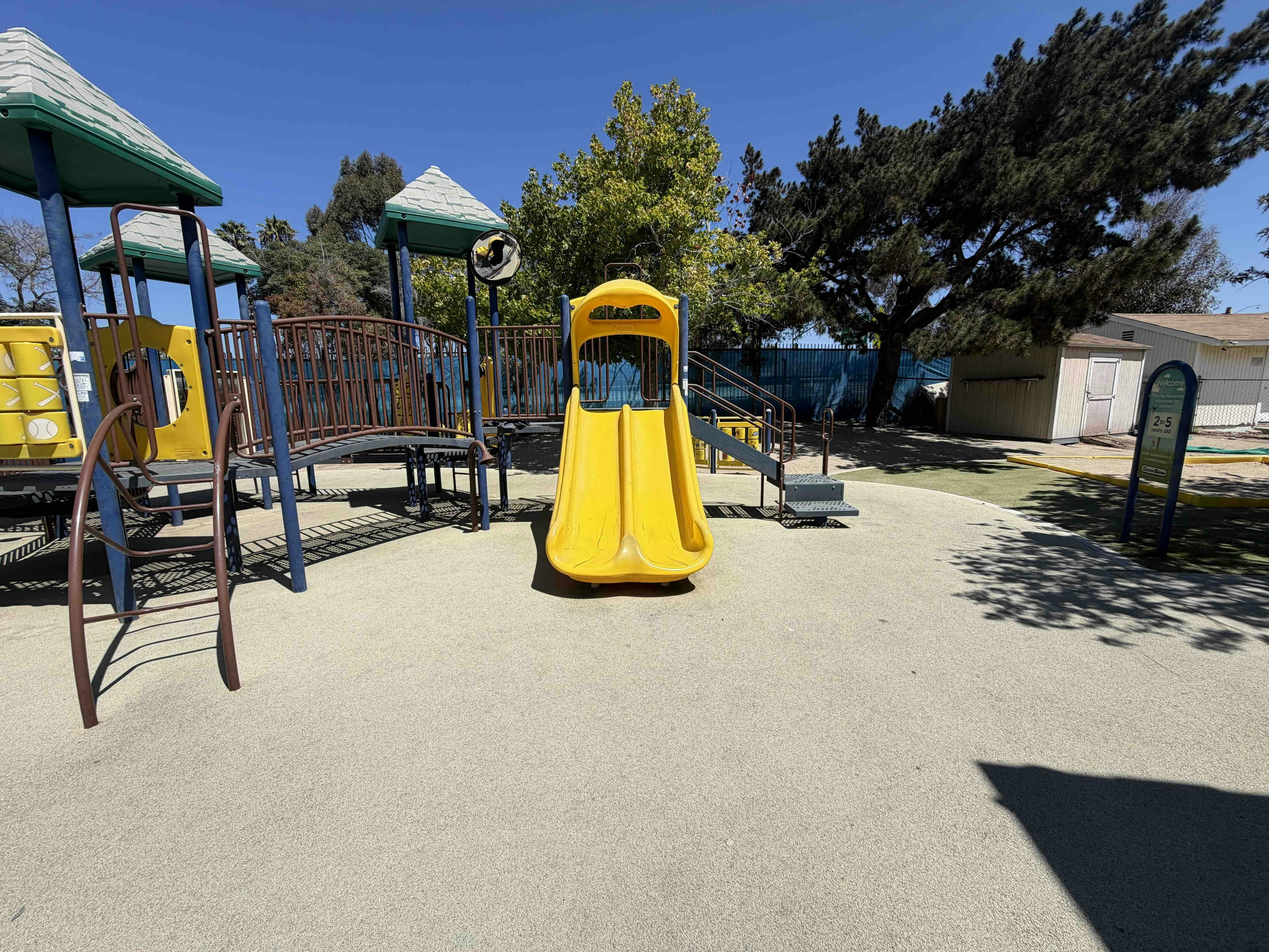 Playground equipment with a yellow slide and elevated platforms