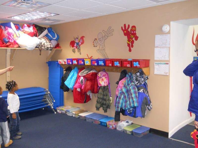 Children in a room with coats hanging on a wall