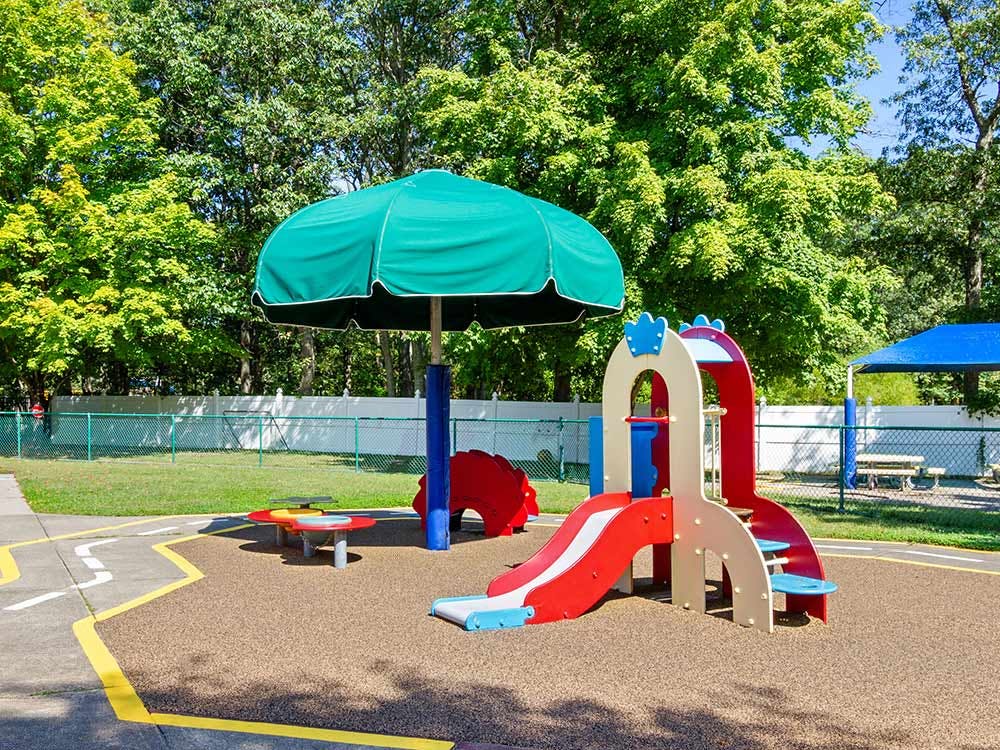 Colorful playground with a slide, umbrella, and a blue shade