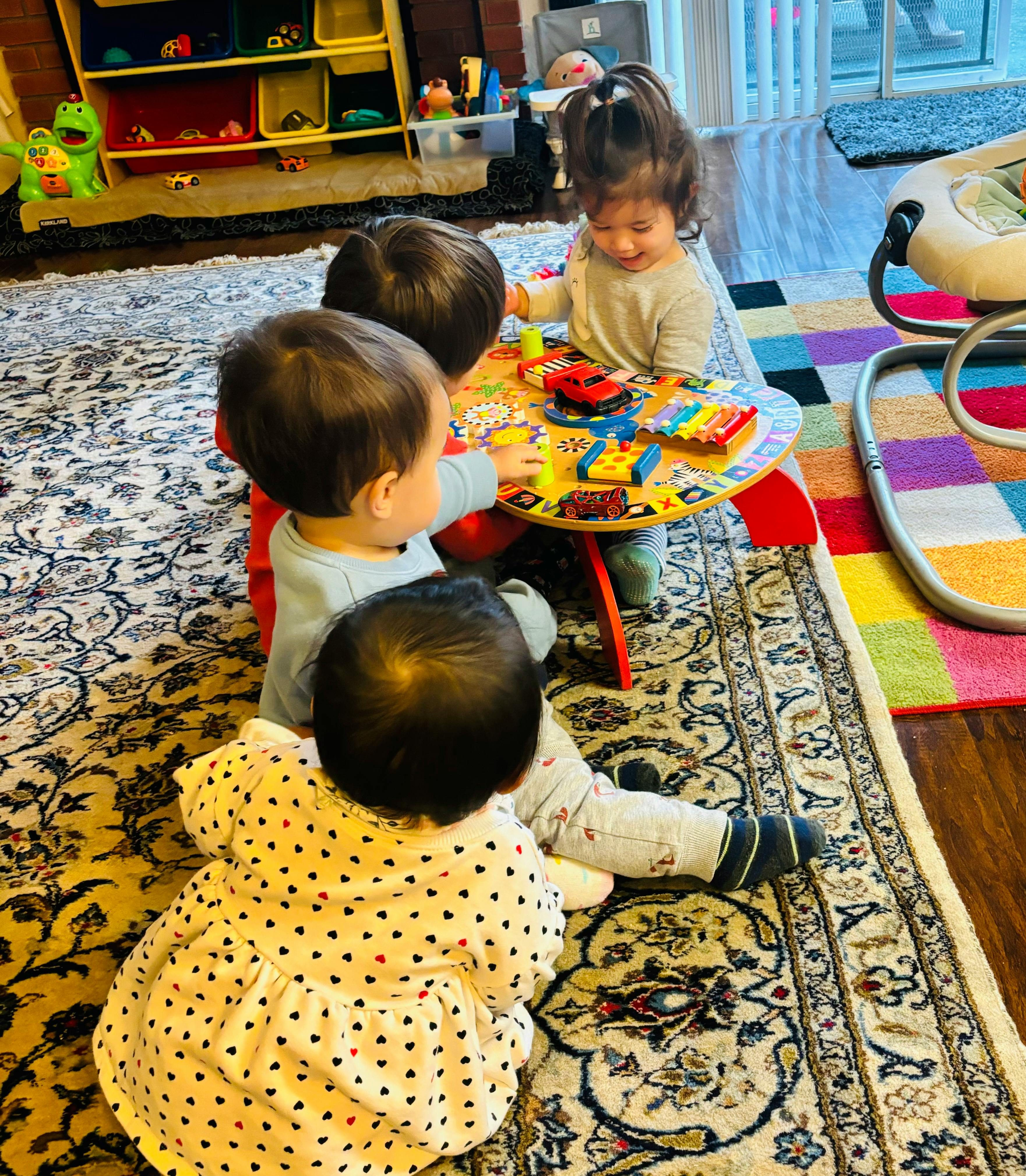 Three children playing with toys at a small table