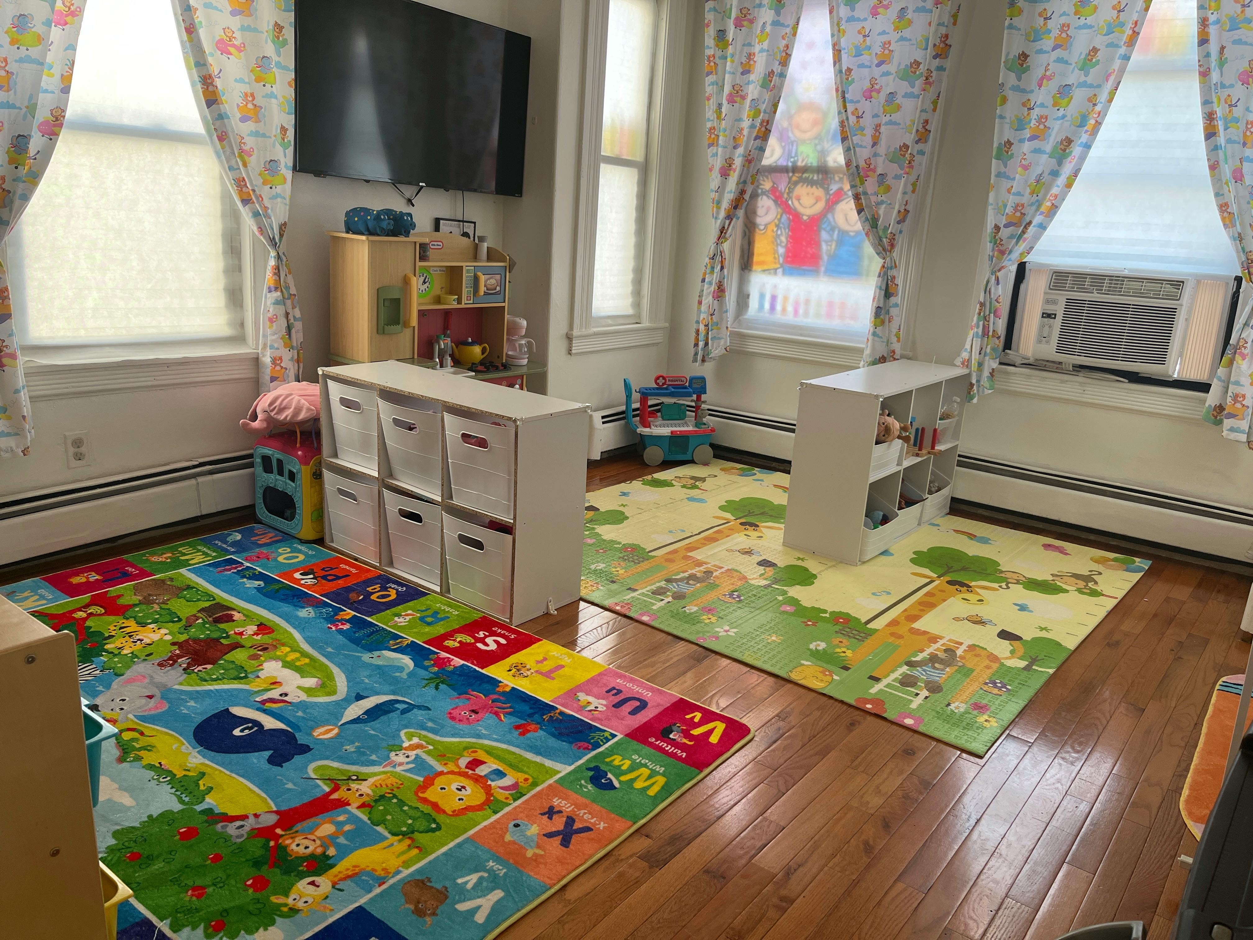 Children's playroom with colorful rugs, toys, and storage bins