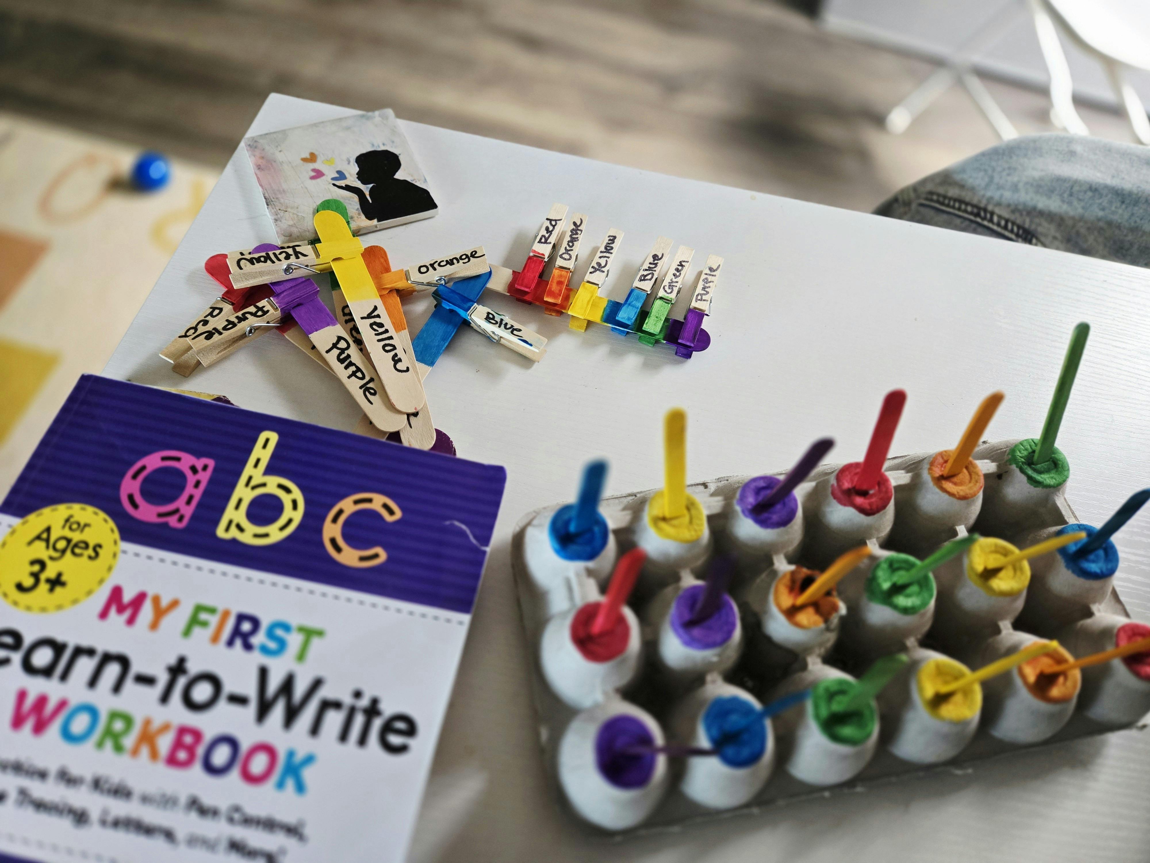 My First Learn-to-Write Workbook with craft sticks and colorful pegs