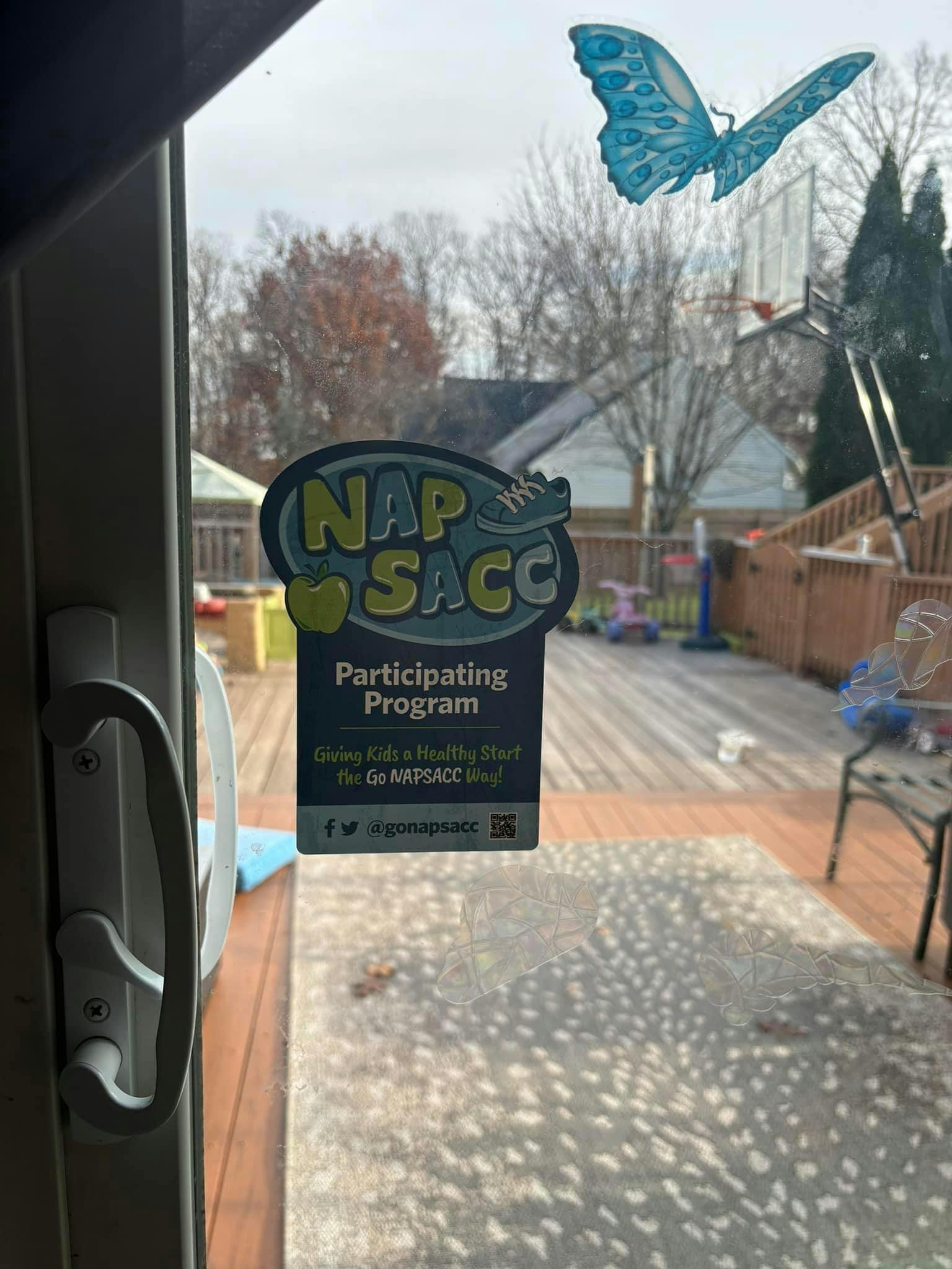 Window with a butterfly sticker and a NAP SACC program sticker