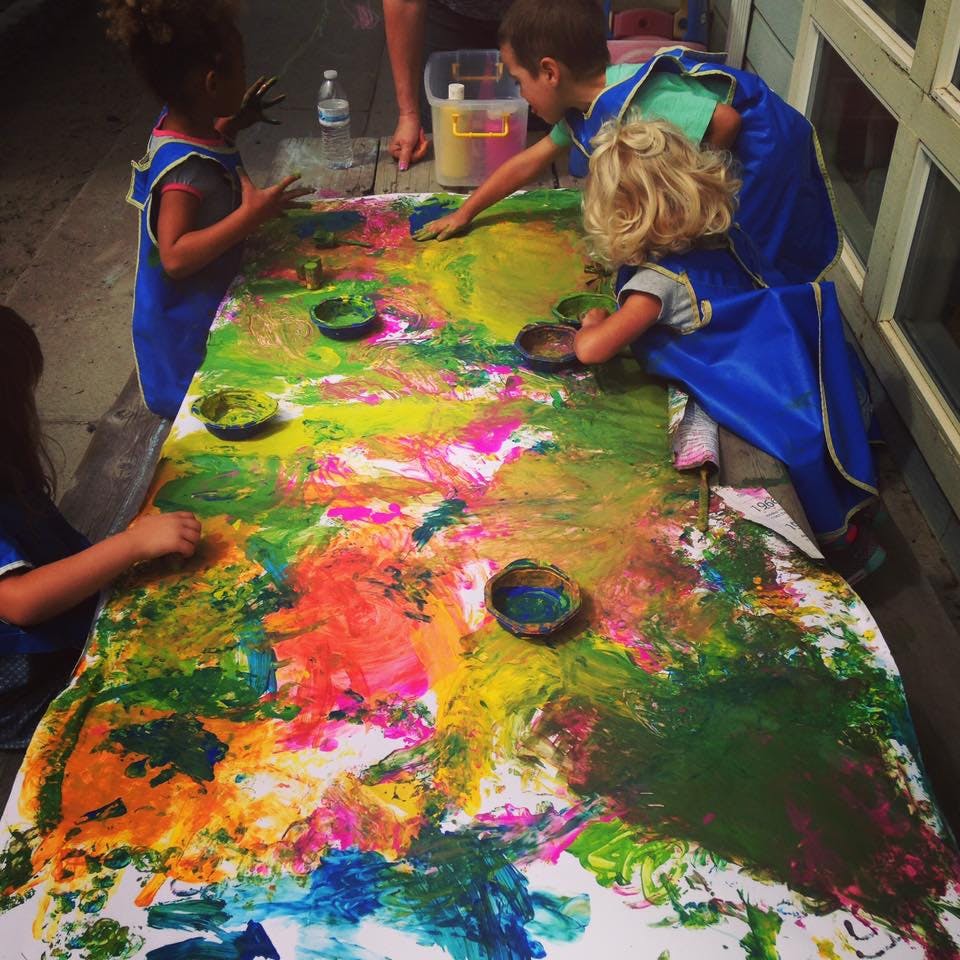 Children painting on a large canvas