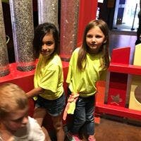 Two children standing next to candy dispensers