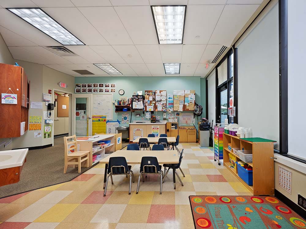 Classroom with tables, chairs, and colorful floor tiles