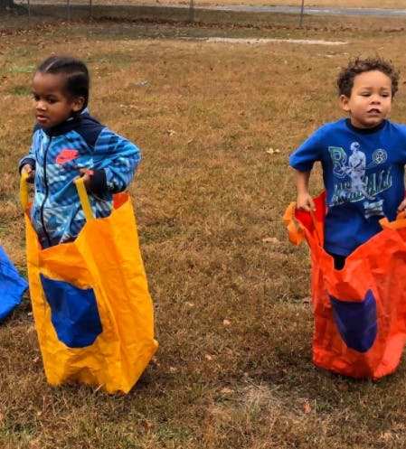 Two children in colorful sacks for a sack race