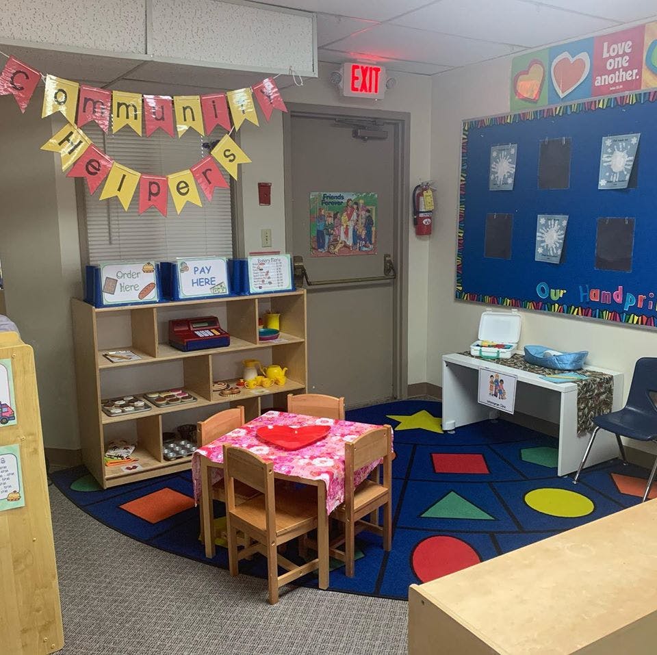 Classroom with small table and chairs, shelving unit, and bulletin board