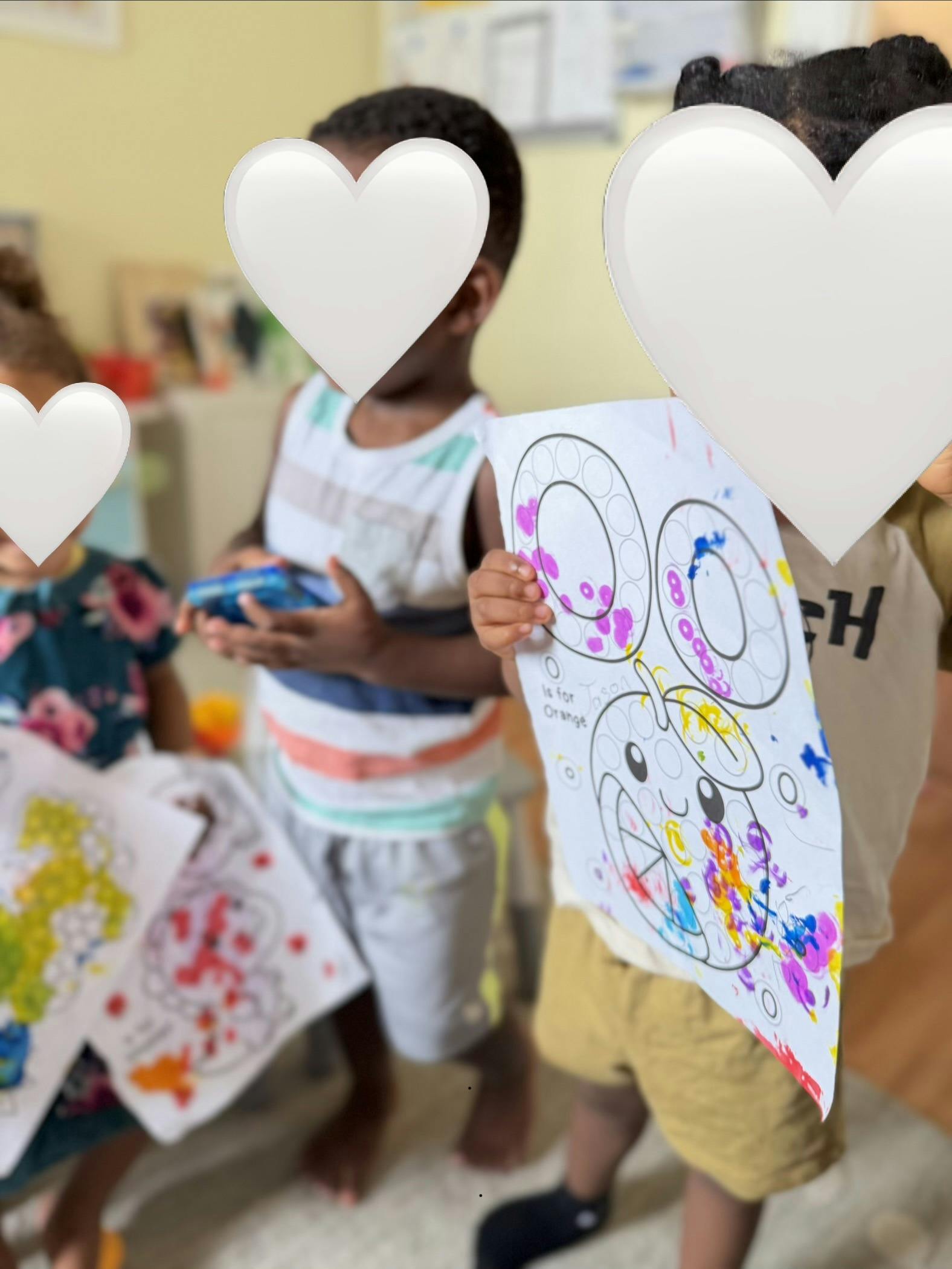 Children holding colorful art projects in a classroom