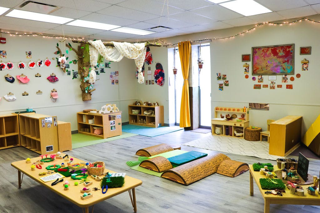 Classroom with tables, shelves, and play mats