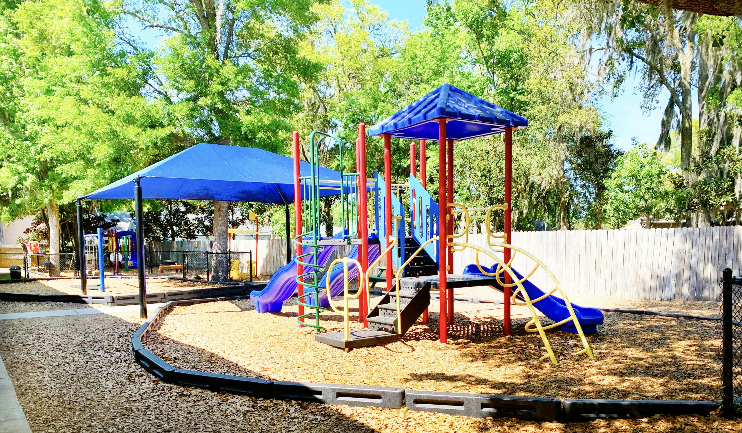 Colorful playground equipment with slides and climbing structures in a park setting