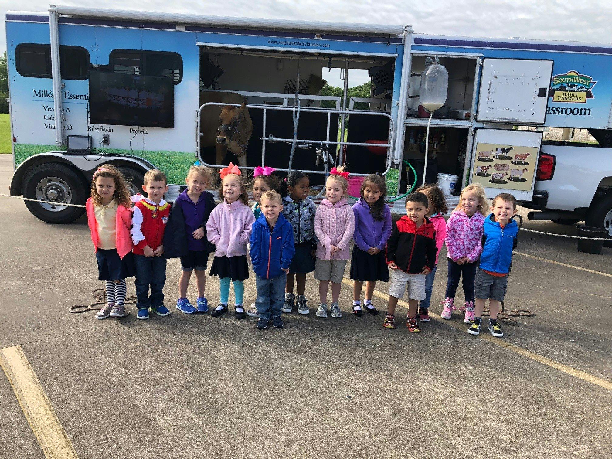 Children standing in front of a mobile dairy classroom