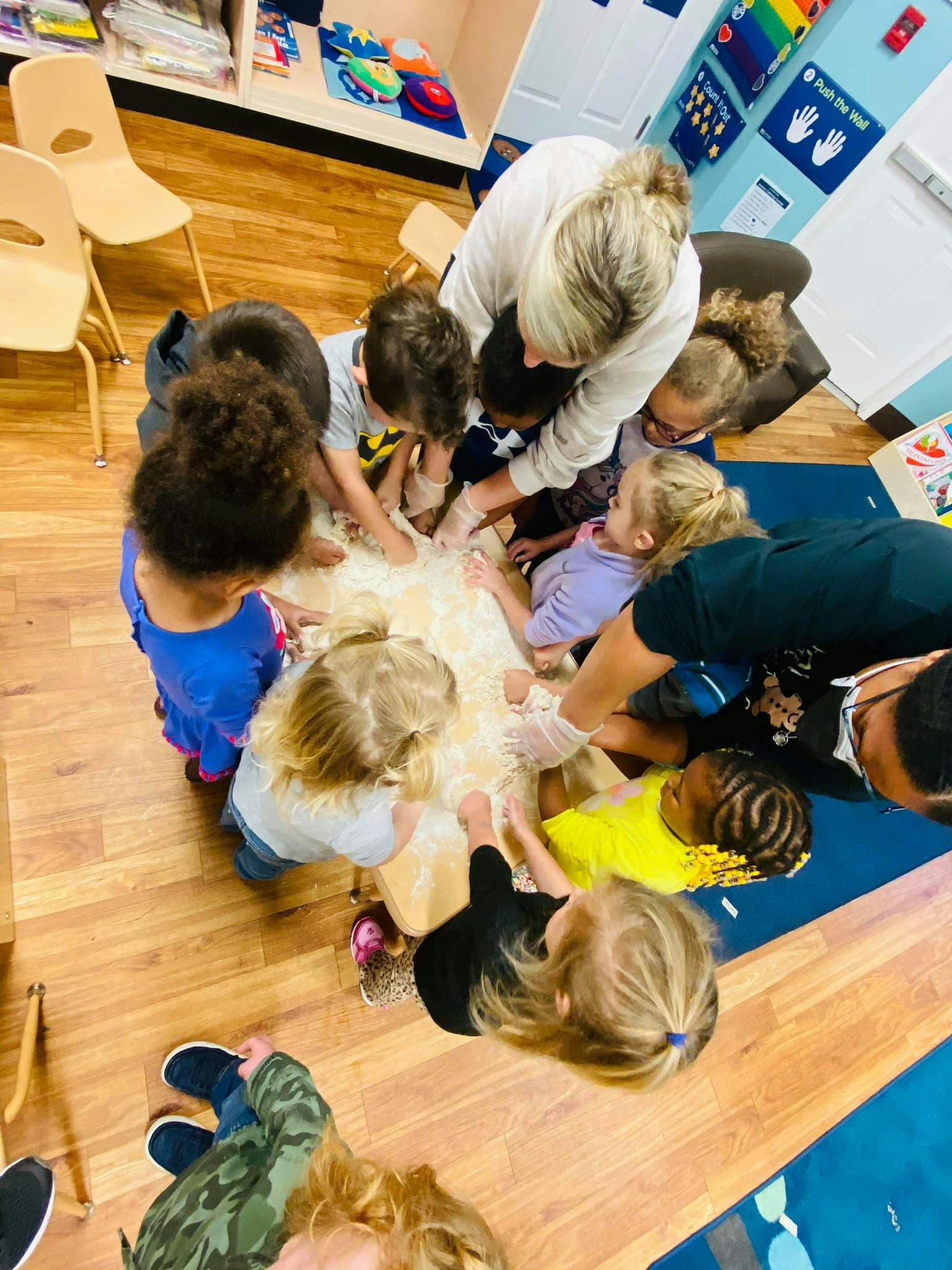 Adults and children gathered around a table, interacting with an object