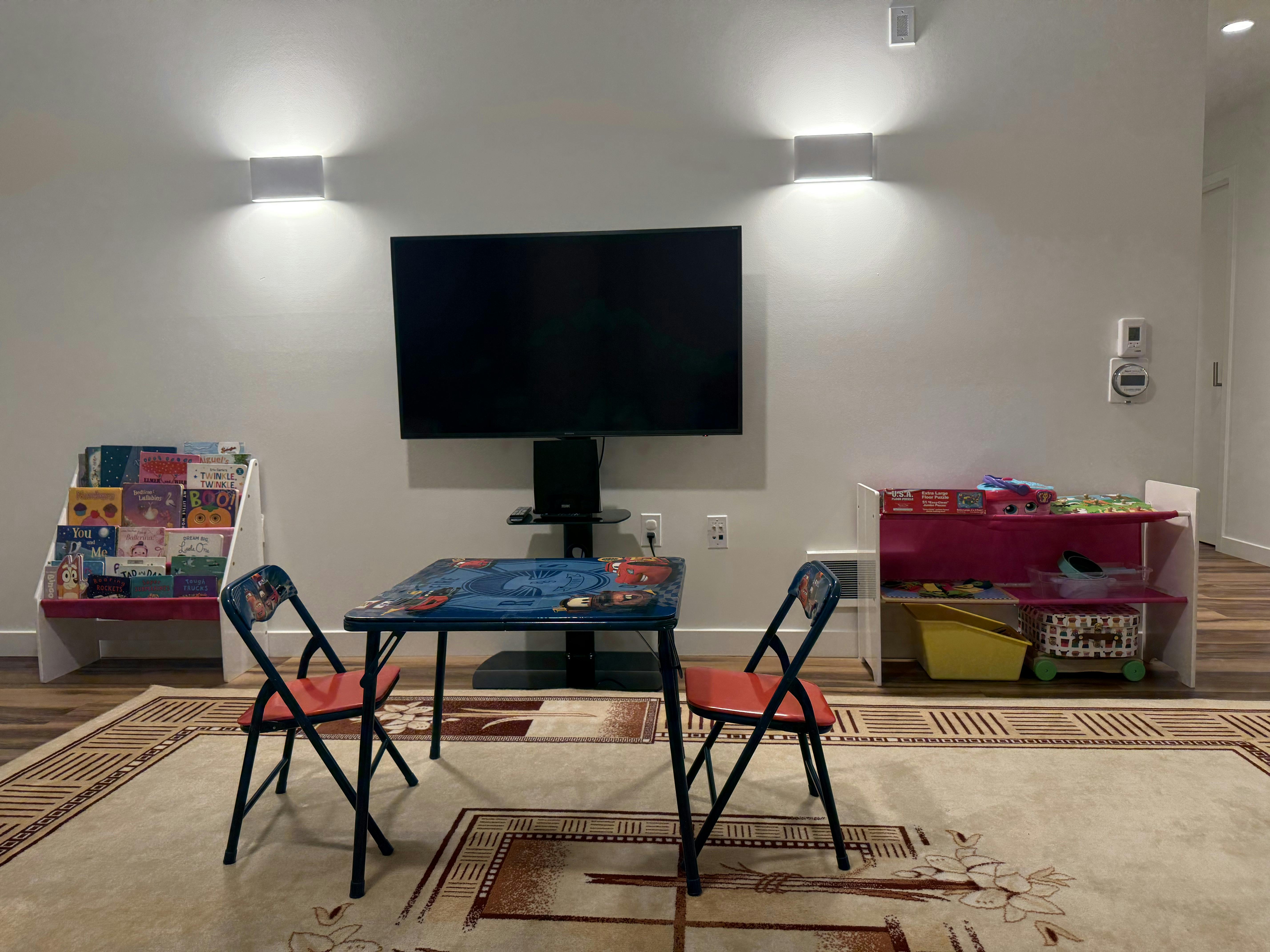 Playroom with a small table and chairs, TV, and toy shelves