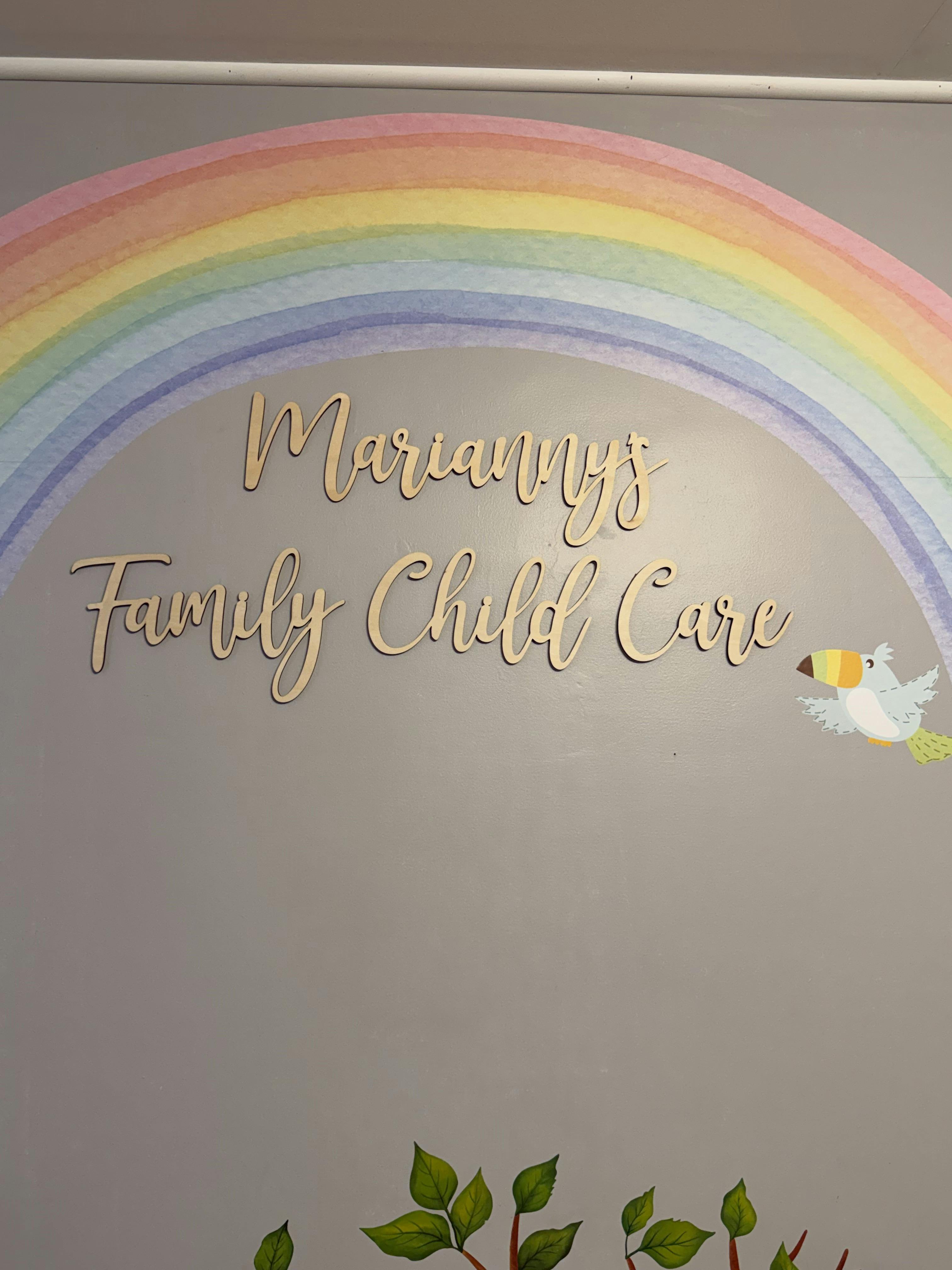 Decorative wall with "Marianny's Family Child Care" in wood letters