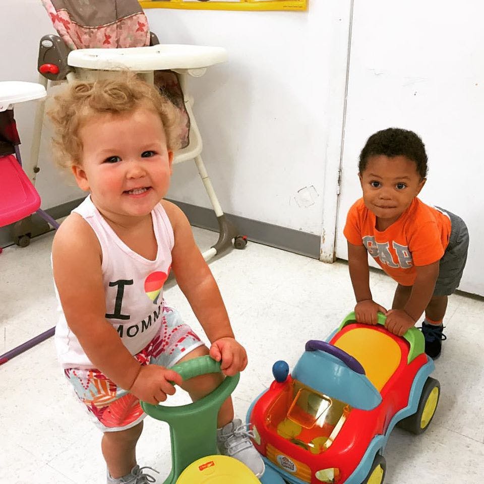 Two children playing with ride-on toys
