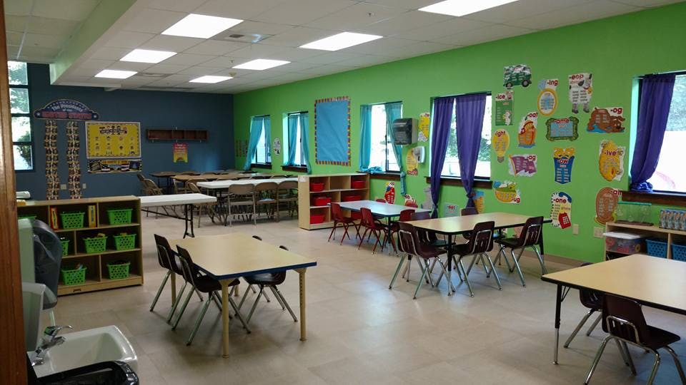 Classroom with small tables and chairs, green and blue walls