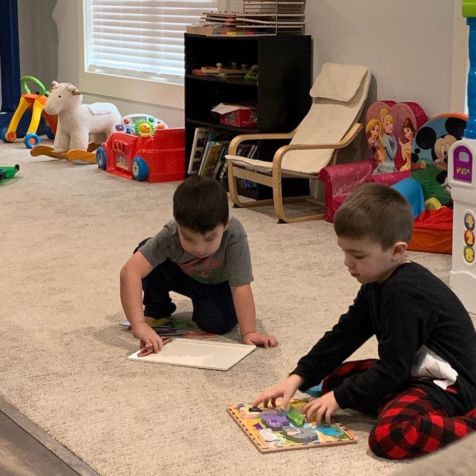 Two children playing with puzzles on the floor