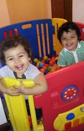 Two children playing in a colorful ball pit