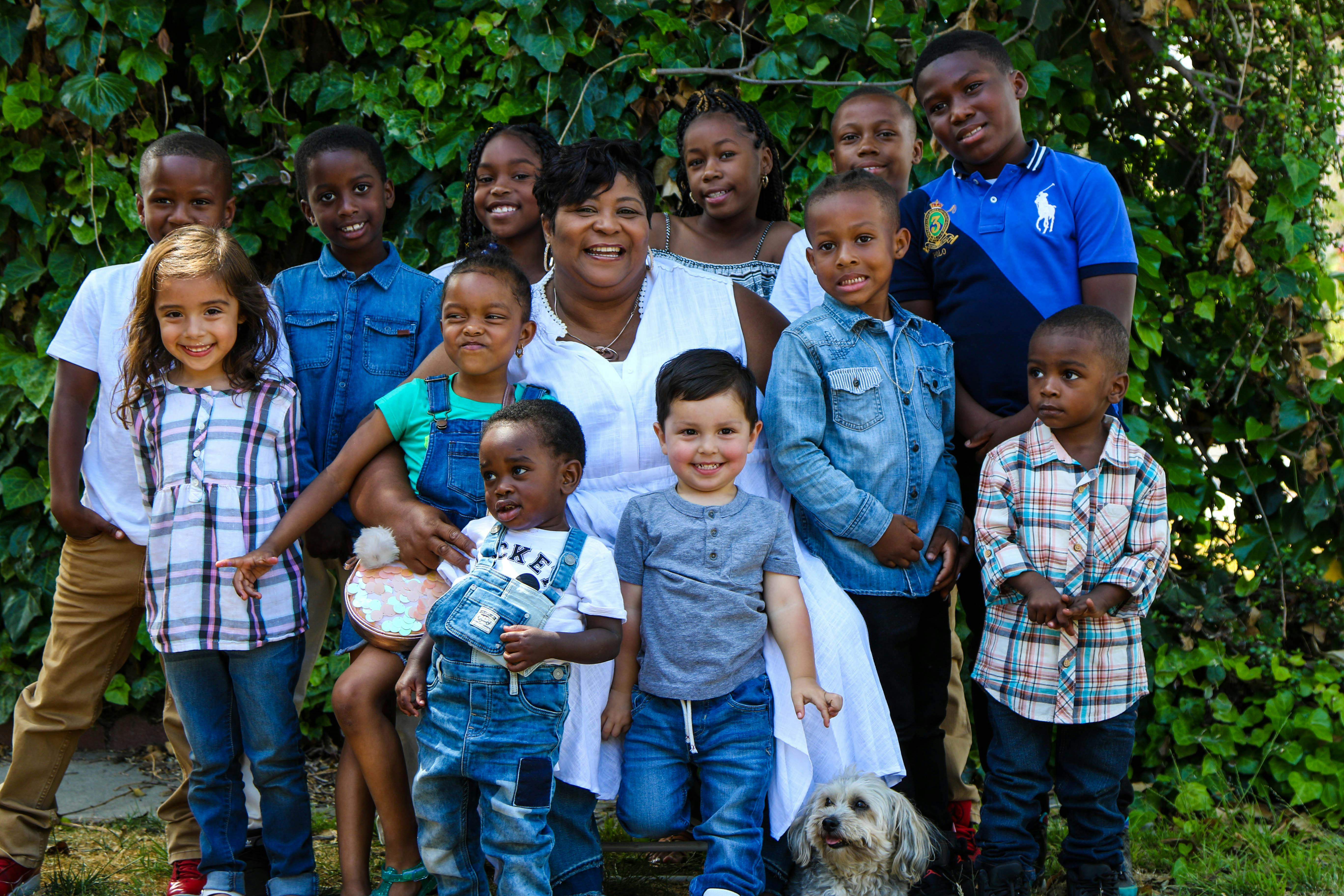 Adult and multiple children posing for a group photo outdoors