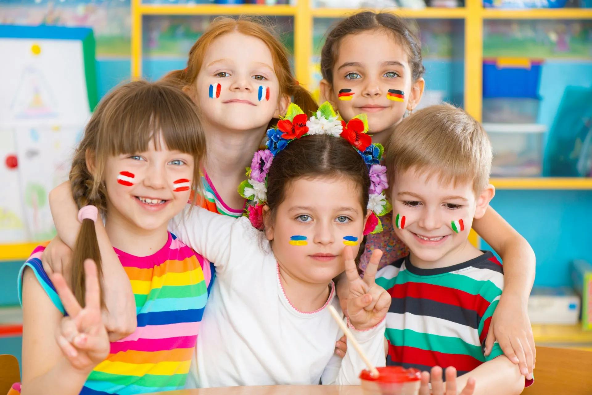 Five children with painted faces smiling at the camera