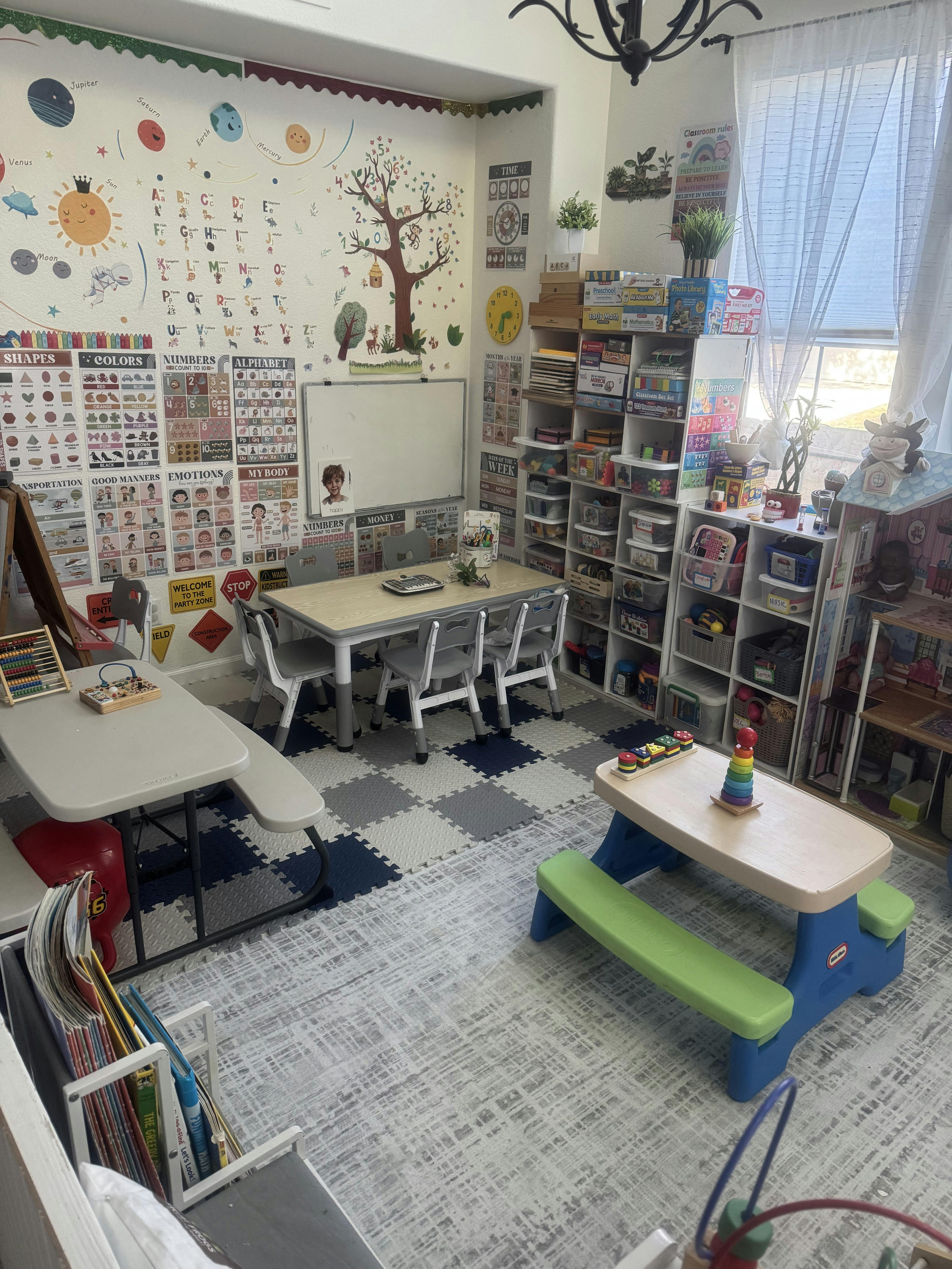 Classroom space for children with tables, chairs, and educational wall charts