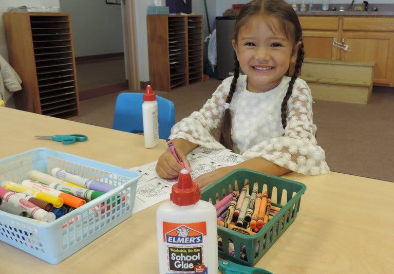 Child at a table with art supplies