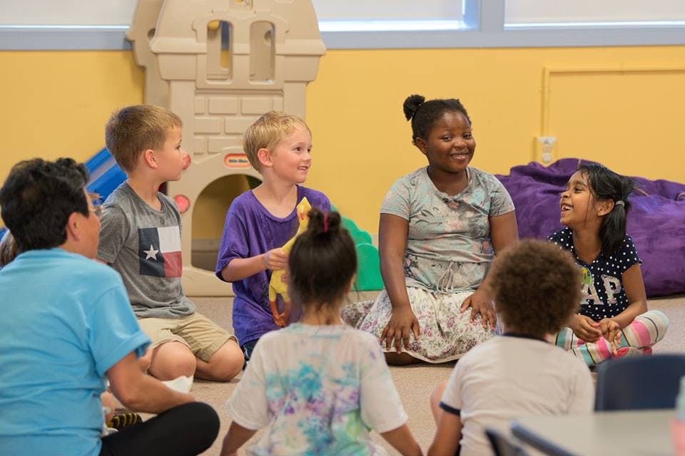 Adult and children sitting in a circle on the floor