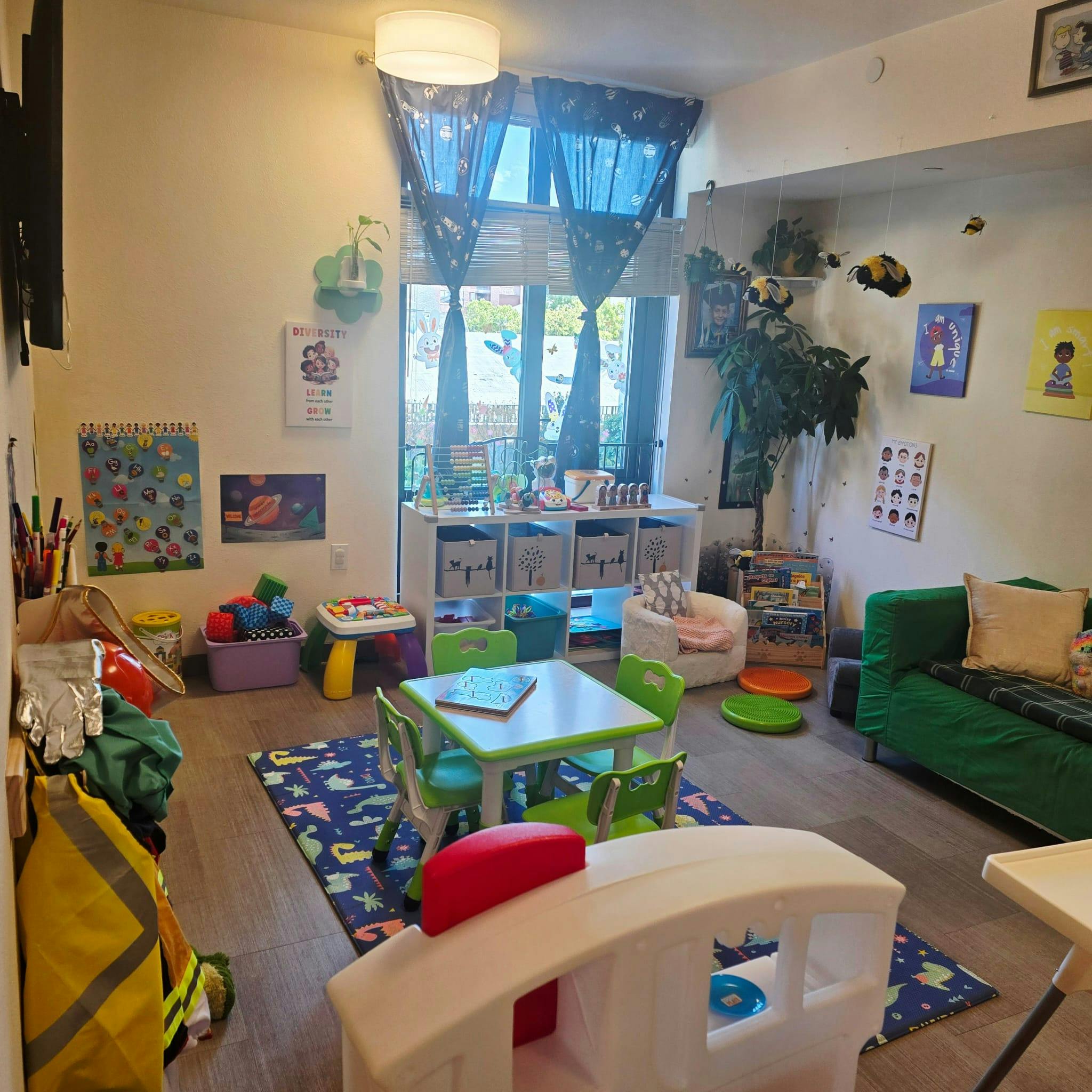 Playroom with small table and chairs, toys, and a green sofa