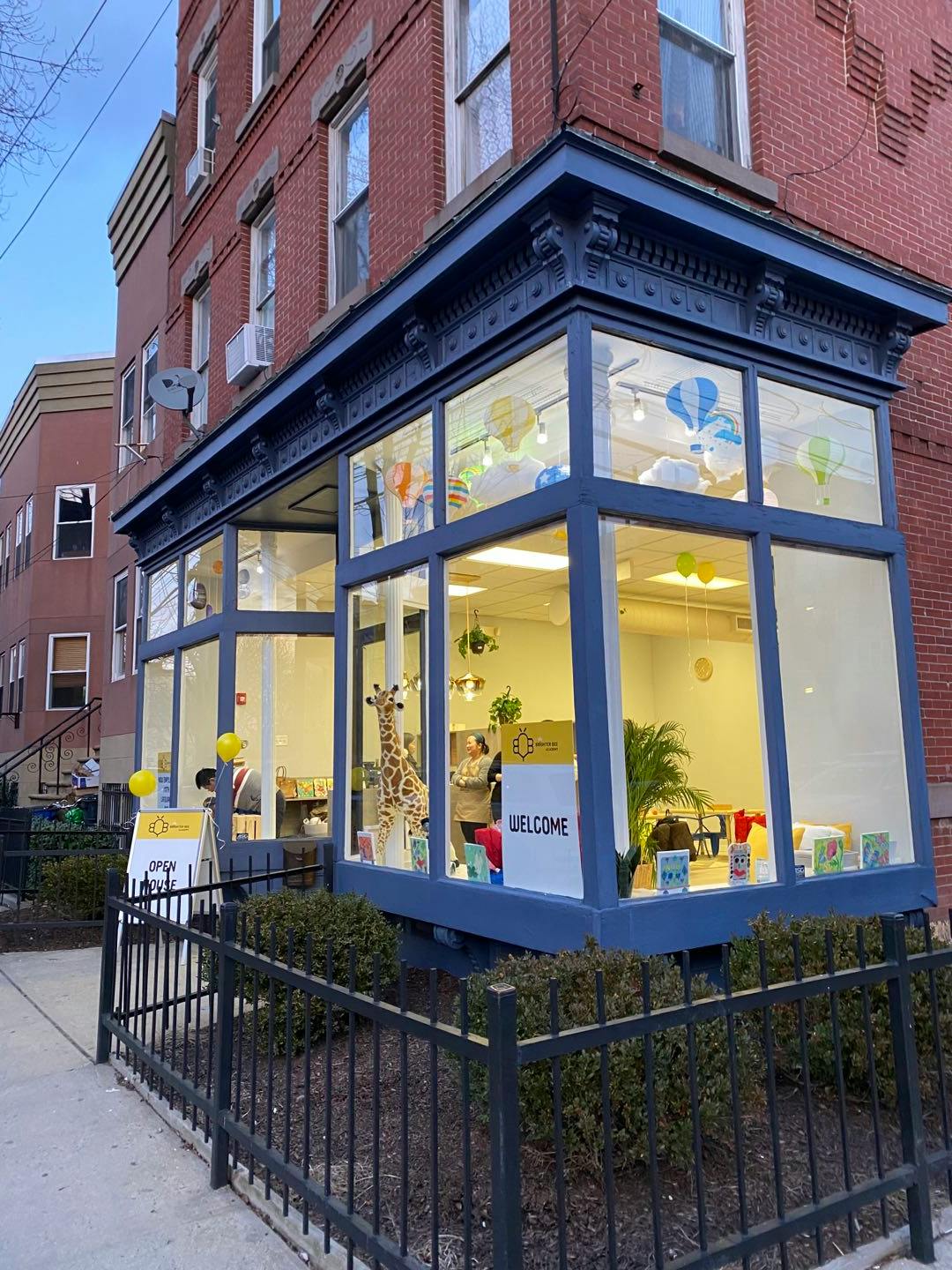 Storefront with large windows and a "WELCOME" sign